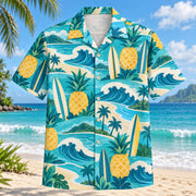 Front view of Pineapple Pop Surfing Hawaiian Shirt with original cut-paper pineapples alongside unbranded surfboards, rolling waves and curved shorelines in a roomy repeat